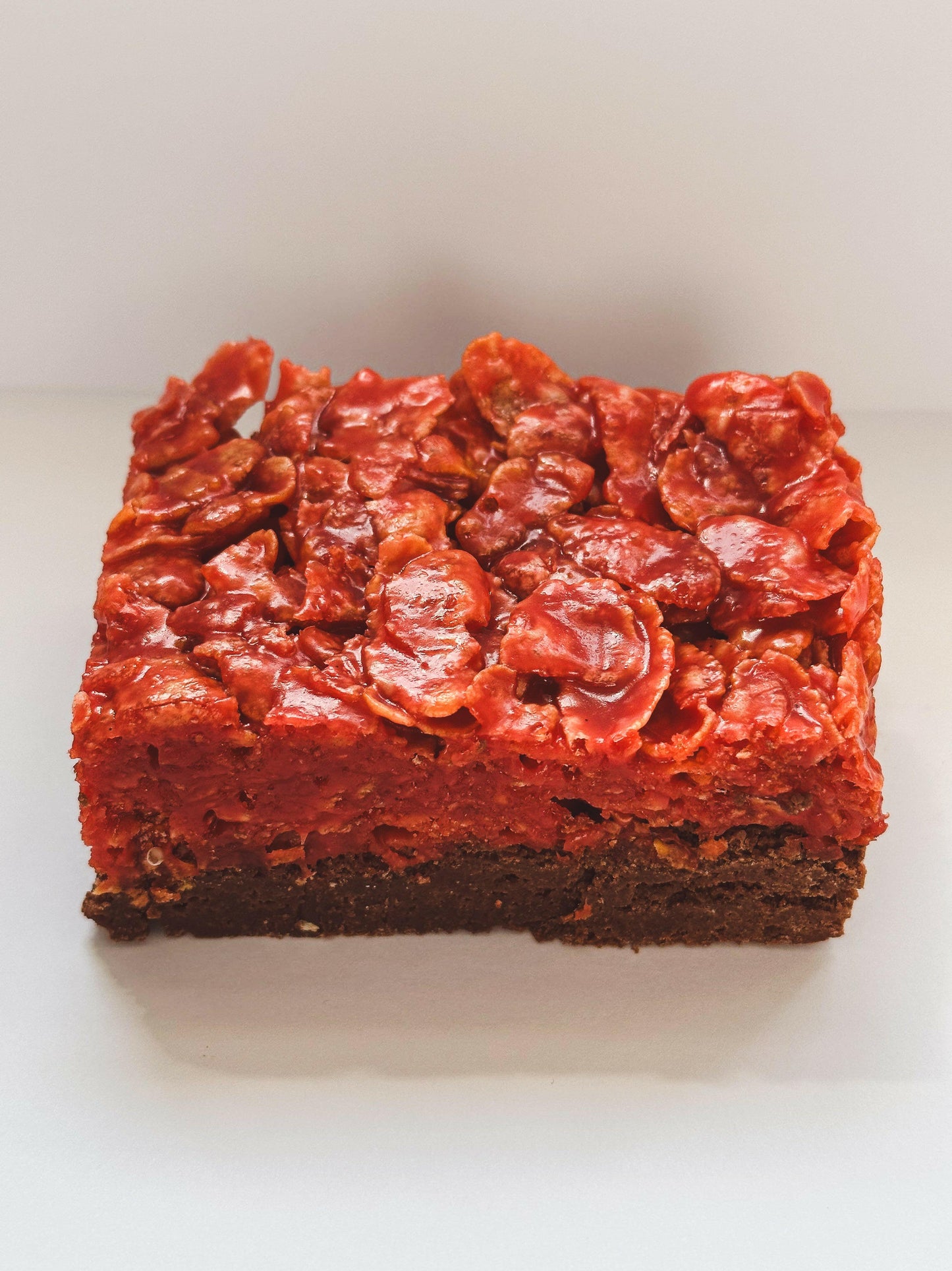 A Halloween-themed cornflake brownie, studded with crunchy cornflakes and drizzled with a spooky caramel sauce, perfect for a hauntingly delicious treat.