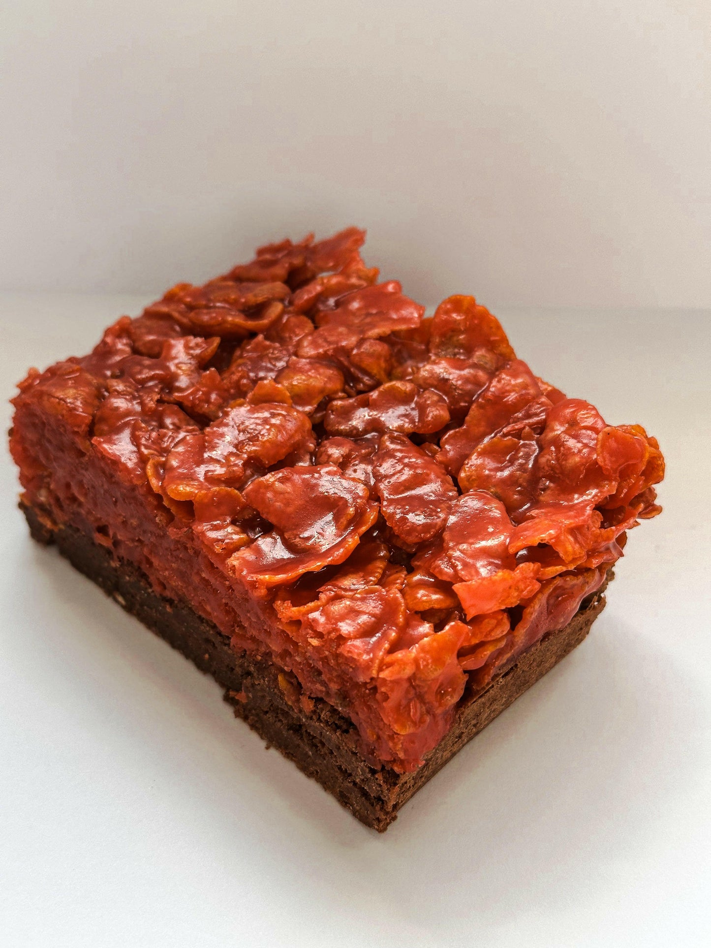 A Halloween-themed cornflake brownie, studded with crunchy cornflakes and drizzled with a spooky caramel sauce, perfect for a hauntingly delicious treat.